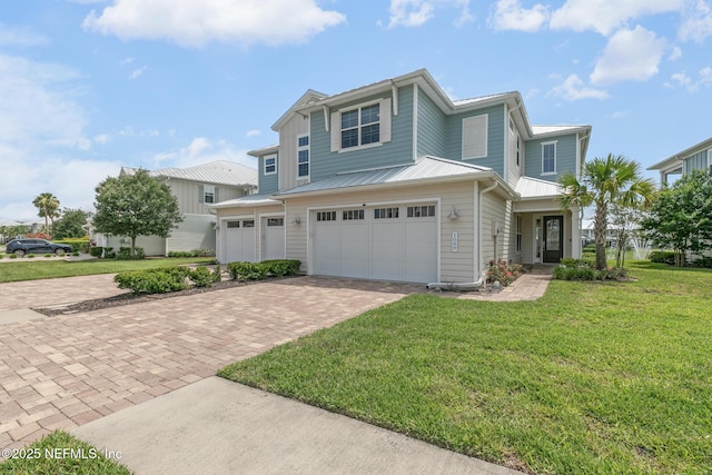106 Rum Runner Way, Saint Johns, FL 32259 - view of front of house with decorative driveway, a front lawn, a garage, and a metal roof