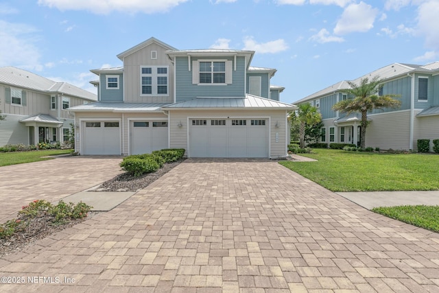 106 Rum Runner Way, Saint Johns, FL 32259 - view of front of property featuring decorative driveway, a front lawn, a garage, and a standing seam roof