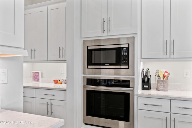 106 Rum Runner Way, Saint Johns, FL 32259 - kitchen with stainless steel appliances, white cabinetry, and light stone countertops