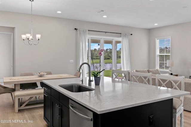 106 Rum Runner Way, Saint Johns, FL 32259 - kitchen with stainless steel dishwasher, dark cabinetry, a chandelier, light wood finished floors, and decorative light fixtures