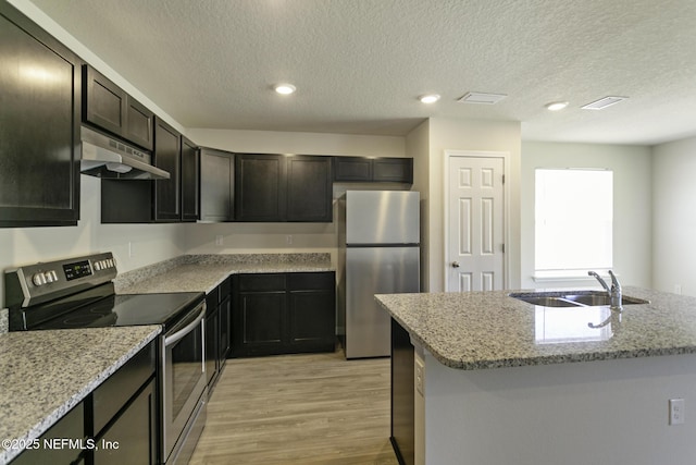 3 Ryecast Pl, Palm Coast, FL 32164 - kitchen with appliances with stainless steel finishes, under cabinet range hood, light wood-style floors, light stone countertops, and a textured ceiling