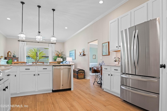 96740 Quartz Ln, Yulee, FL 32097 - kitchen featuring stainless steel appliances, ornamental molding, white cabinetry, light wood finished floors, and recessed lighting