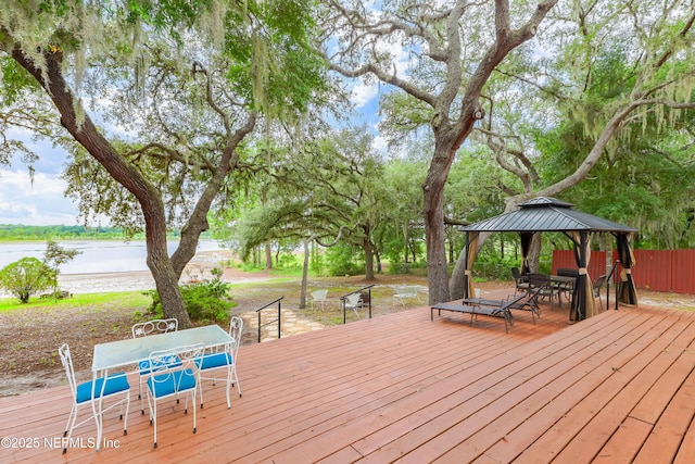 5299 County Road 352nd Rd, Keystone Heights, FL 32656 - wooden deck with outdoor dining area, a gazebo, a water view, and view of wooded area