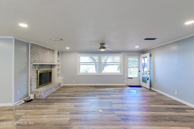 5299 County Road 352nd Rd, Keystone Heights, FL 32656 - unfurnished living room with crown molding, ceiling fan, a brick fireplace, recessed lighting, and wood finished floors