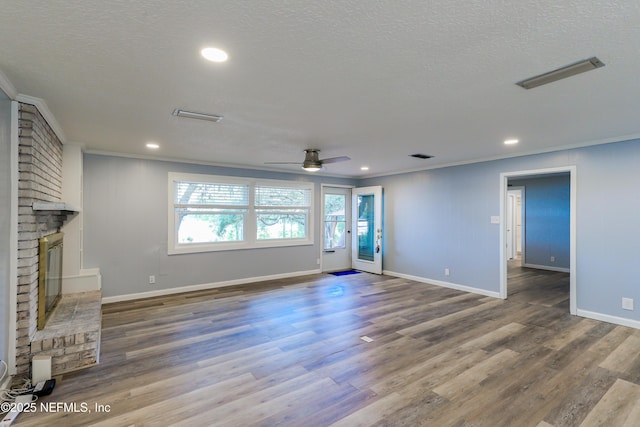 5299 County Road 352nd Rd, Keystone Heights, FL 32656 - unfurnished living room with ornamental molding, a fireplace, wood finished floors, a ceiling fan, and a textured ceiling