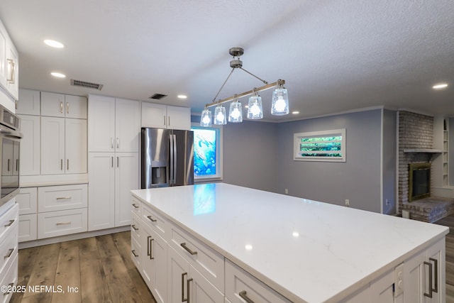 5299 County Road 352nd Rd, Keystone Heights, FL 32656 - kitchen featuring appliances with stainless steel finishes, white cabinets, wood finished floors, recessed lighting, and a textured ceiling