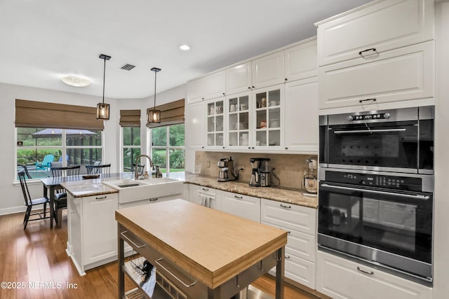 1805 Commodore Point Dr, Fleming Island, FL 32003 - kitchen with double oven, a peninsula, glass insert cabinets, white cabinetry, and backsplash