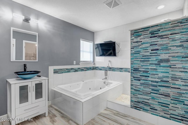 1069 Ardmore St, Saint Augustine, FL 32092 - bathroom with wood finished floors, a whirlpool tub, vanity, and a textured ceiling