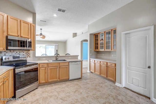 1069 Ardmore St, Saint Augustine, FL 32092 - kitchen featuring stainless steel appliances, arched walkways, a peninsula, light countertops, and a ceiling fan
