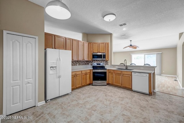1069 Ardmore St, Saint Augustine, FL 32092 - kitchen featuring appliances with stainless steel finishes, a peninsula, light countertops, a textured ceiling, and ceiling fan