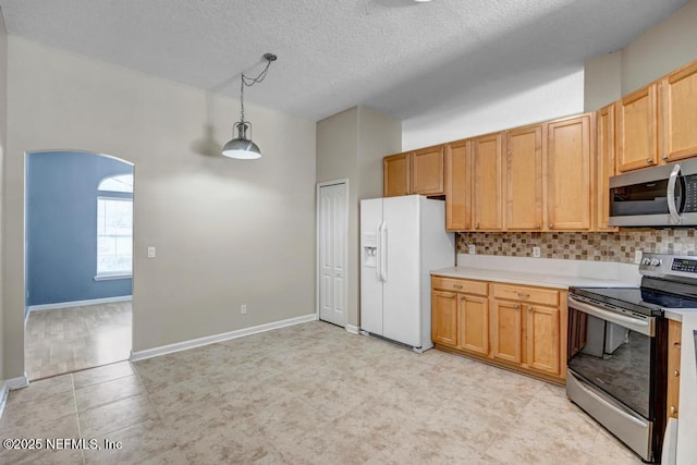 1069 Ardmore St, Saint Augustine, FL 32092 - kitchen with appliances with stainless steel finishes, arched walkways, light countertops, pendant lighting, and a textured ceiling