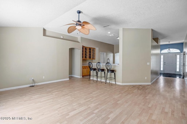 1069 Ardmore St, Saint Augustine, FL 32092 - living area featuring light wood finished floors, a ceiling fan, a textured ceiling, and arched walkways