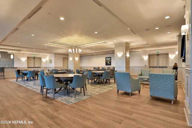 1031 1st St S Unit 504, Jacksonville Beach, FL 32250 - dining room featuring a raised ceiling, a decorative wall, light wood finished floors, recessed lighting, and a wainscoted wall