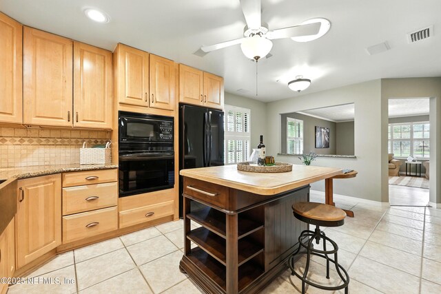 726 Arran Ct, Orange Park, FL 32073 - kitchen with black appliances, light brown cabinets, light tile patterned floors, a breakfast bar area, and decorative backsplash