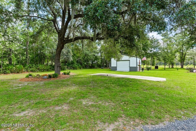 26122 Sheared Stokes Rd, Hilliard, FL 32046 - view of green lawn featuring a detached garage, an outbuilding, and concrete driveway