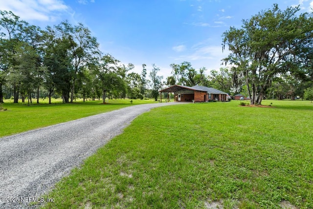 26122 Sheared Stokes Rd, Hilliard, FL 32046 - view of front facade featuring a carport, gravel driveway, and a front lawn
