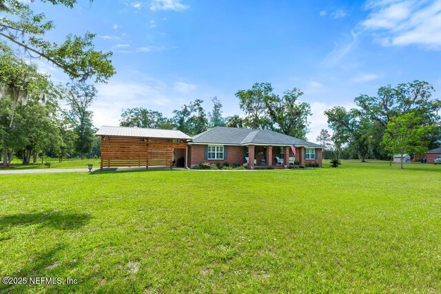 26122 Sheared Stokes Rd, Hilliard, FL 32046 - ranch-style house featuring a front lawn and a porch