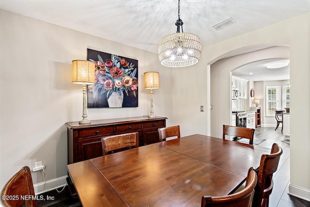 26122 Sheared Stokes Rd, Hilliard, FL 32046 - dining room with arched walkways and a chandelier