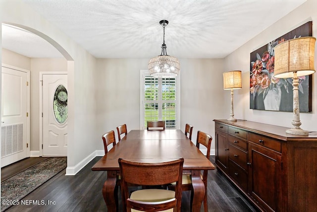 26122 Sheared Stokes Rd, Hilliard, FL 32046 - dining space with arched walkways, dark wood finished floors, and a chandelier