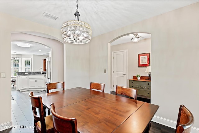 26122 Sheared Stokes Rd, Hilliard, FL 32046 - dining area with arched walkways and a chandelier