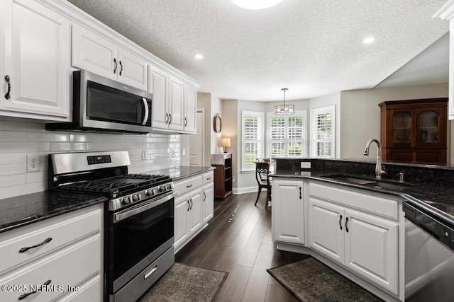 26122 Sheared Stokes Rd, Hilliard, FL 32046 - kitchen featuring stainless steel appliances, white cabinets, decorative backsplash, a textured ceiling, and recessed lighting