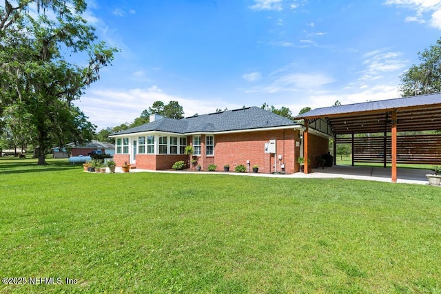 26122 Sheared Stokes Rd, Hilliard, FL 32046 - back of property with brick siding, a yard, and a carport