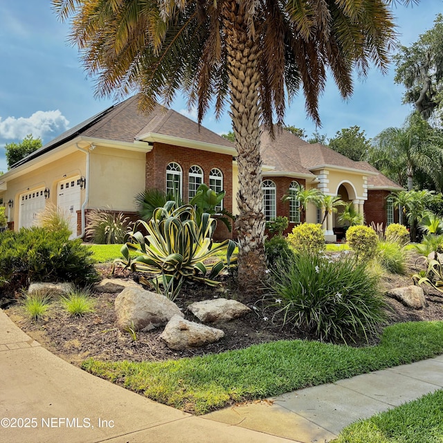 8 Ivey Ln, Flagler Beach, FL 32136 - view of front facade with an attached garage and stucco siding