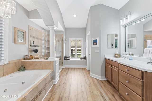 1317 Garrison Dr, Saint Augustine, FL 32092 - full bath featuring ornate columns, a stall shower, a whirlpool tub, vanity, and wood finished floors