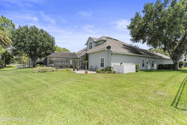 1317 Garrison Dr, Saint Augustine, FL 32092 - rear view of house featuring stucco siding, a yard, a shingled roof, and glass enclosure