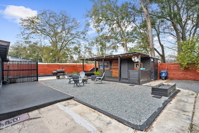 479 Tara Ln, Orange Park, FL 32073 - fenced backyard featuring an outdoor structure, a wooden deck, and a patio area