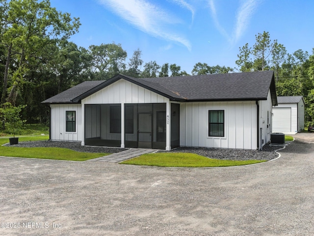 432 SE 55th St, Keystone Heights, FL 32656 - modern farmhouse style home with roof with shingles, board and batten siding, a detached garage, and a sunroom