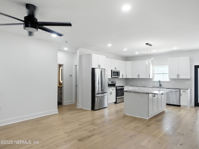 432 SE 55th St, Keystone Heights, FL 32656 - kitchen featuring appliances with stainless steel finishes, ceiling fan, recessed lighting, a kitchen island, and white cabinetry