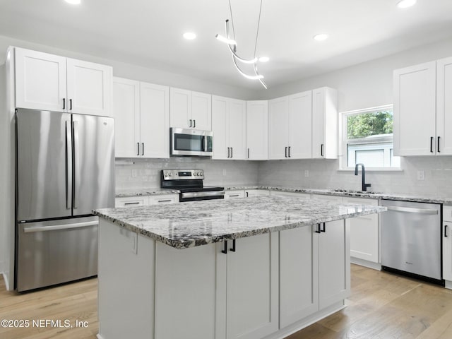 432 SE 55th St, Keystone Heights, FL 32656 - kitchen with stainless steel appliances, a center island, white cabinets, decorative backsplash, and recessed lighting