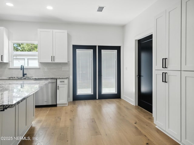 432 SE 55th St, Keystone Heights, FL 32656 - kitchen with stainless steel dishwasher, white cabinetry, french doors, decorative backsplash, and recessed lighting