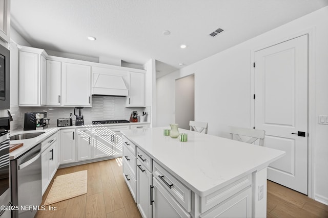 322 Fairlake Cir, Saint Augustine, FL 32092 - kitchen featuring stainless steel dishwasher, custom range hood, recessed lighting, a center island, and backsplash