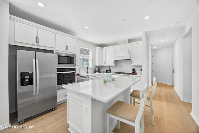 322 Fairlake Cir, Saint Augustine, FL 32092 - kitchen with stainless steel appliances, custom range hood, white cabinets, a breakfast bar, and light countertops