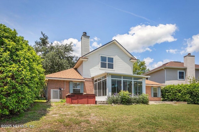 1385 Soaring Flight Way, Jacksonville, FL 32225 - rear view of property with a hot tub, a sunroom, brick siding, a lawn, and a chimney
