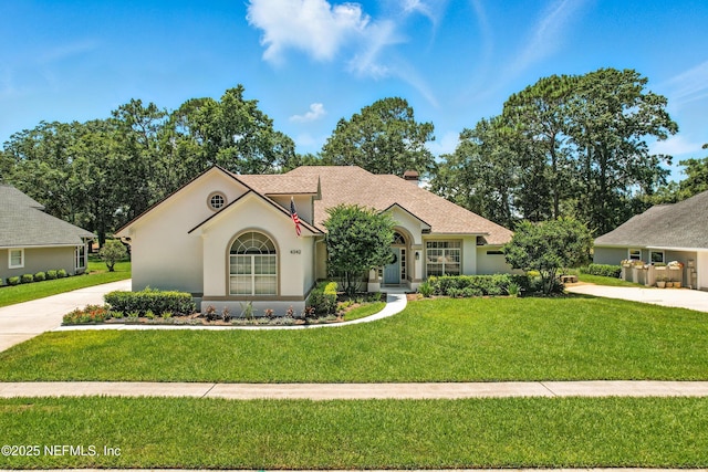 4342 Richmond Park Dr E, Jacksonville, FL 32224 - view of front of house with a front lawn, stucco siding, concrete driveway, and roof with shingles