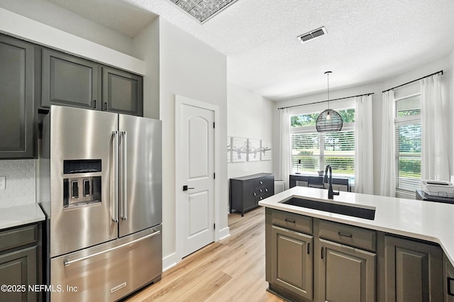 4342 Richmond Park Dr E, Jacksonville, FL 32224 - kitchen featuring high end fridge, light wood-type flooring, light countertops, backsplash, and decorative light fixtures