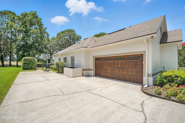 4342 Richmond Park Dr E, Jacksonville, FL 32224 - view of side of property with a shingled roof, asphalt driveway, a garage, and stucco siding