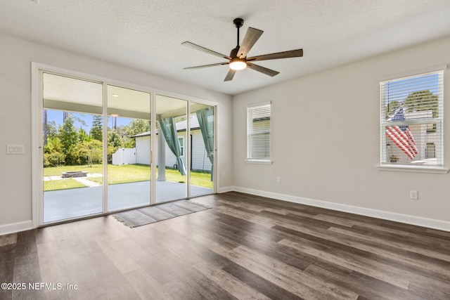 94954 Colnago Ct, Fernandina Beach, FL 32034 - empty room featuring a ceiling fan, healthy amount of natural light, dark wood-type flooring, and a textured ceiling