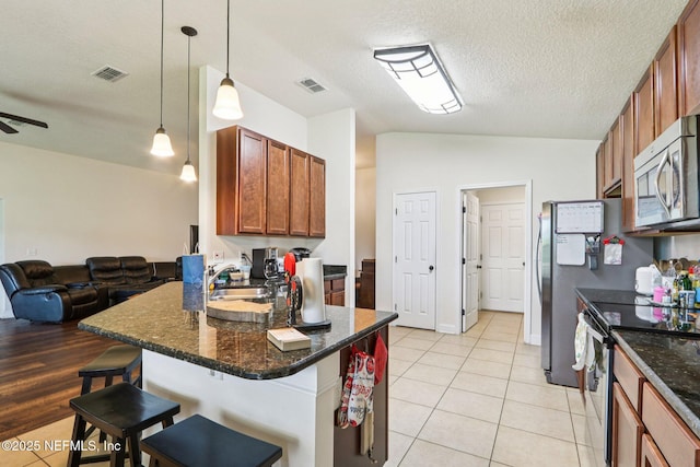 2947 Vianey Pl, Green Cove Springs, FL 32043 - kitchen with appliances with stainless steel finishes, open floor plan, a kitchen breakfast bar, light tile patterned flooring, and a peninsula