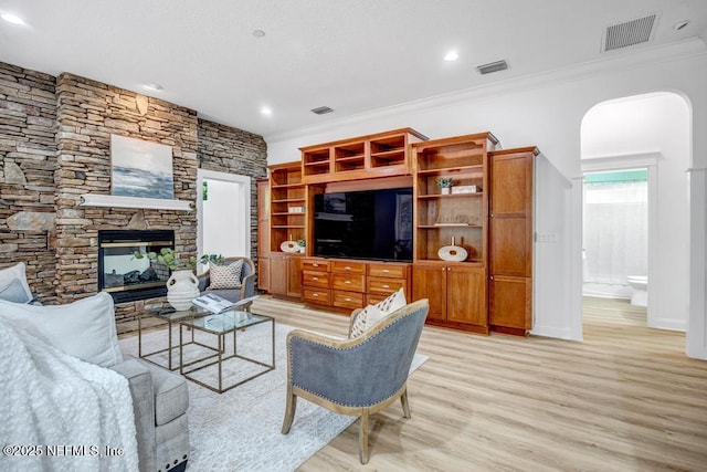 2200 Durbin Creek Blvd, Saint Johns, FL 32259 - living area featuring light wood finished floors, crown molding, arched walkways, a stone fireplace, and recessed lighting