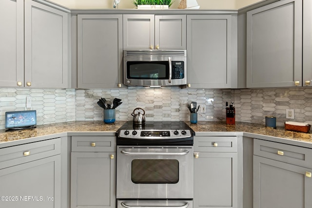 308 High Tide Dr Unit 201, Saint Augustine, FL 32080 - kitchen featuring appliances with stainless steel finishes, tile counters, gray cabinetry, and tasteful backsplash