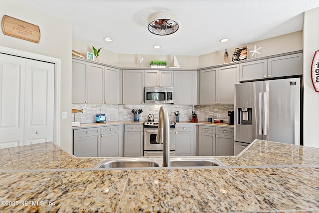 308 High Tide Dr Unit 201, Saint Augustine, FL 32080 - kitchen with stainless steel appliances, gray cabinetry, backsplash, and recessed lighting