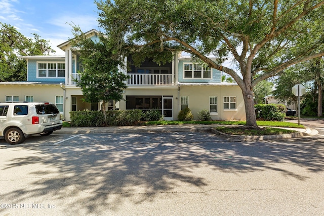 308 High Tide Dr Unit 201, Saint Augustine, FL 32080 - view of front of property with stucco siding, uncovered parking, and a balcony