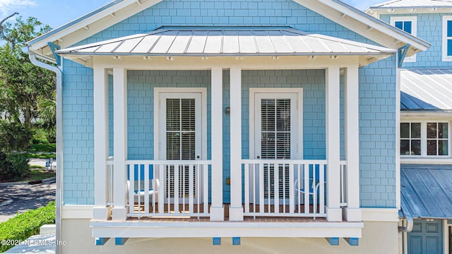 308 High Tide Dr Unit 201, Saint Augustine, FL 32080 - view of exterior entry with a standing seam roof, a metal roof, and a porch