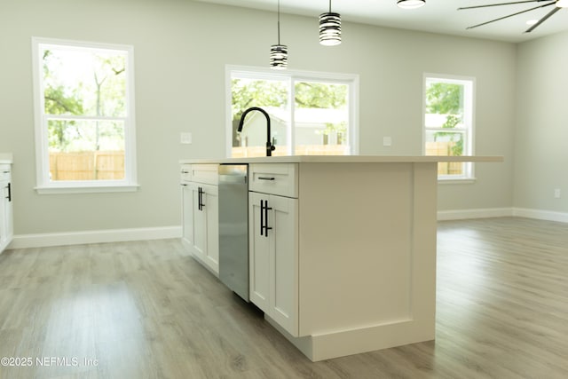 5408 Potomac Ave, Jacksonville, FL 32254 - kitchen featuring light wood-style flooring, light countertops, white cabinetry, and decorative light fixtures