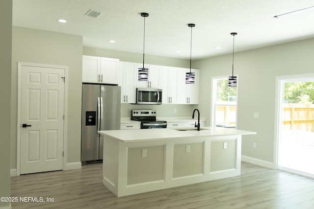 5408 Potomac Ave, Jacksonville, FL 32254 - kitchen featuring stainless steel appliances, light wood-type flooring, plenty of natural light, white cabinetry, and recessed lighting
