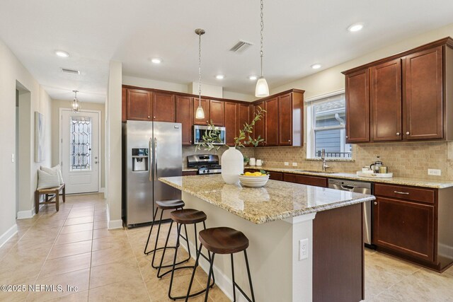 48 Gilchrist Way, Saint Johns, FL 32092 - kitchen with stainless steel appliances, tasteful backsplash, a kitchen bar, a kitchen island, and recessed lighting